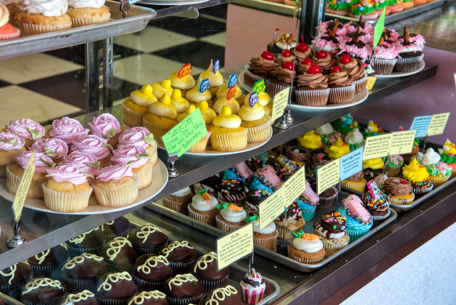 Decorated celebration cakes and cupcakes on bakery display