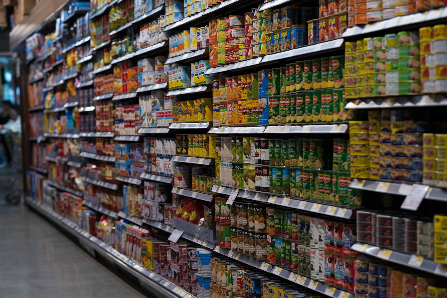 Variety of international canned goods and pantry staples on supermarket shelves