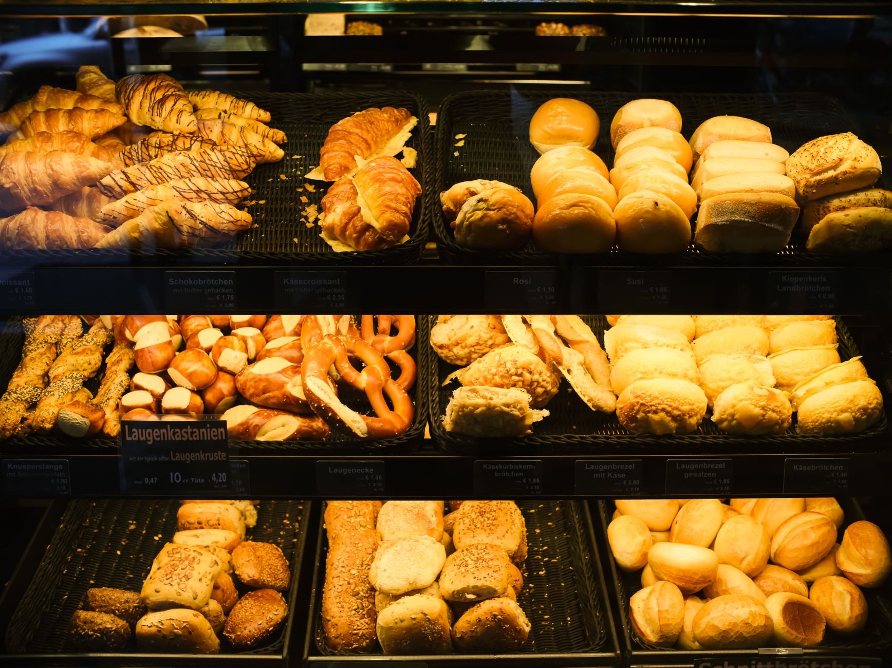 Assorted freshly baked pastries and croissants in bakery display case