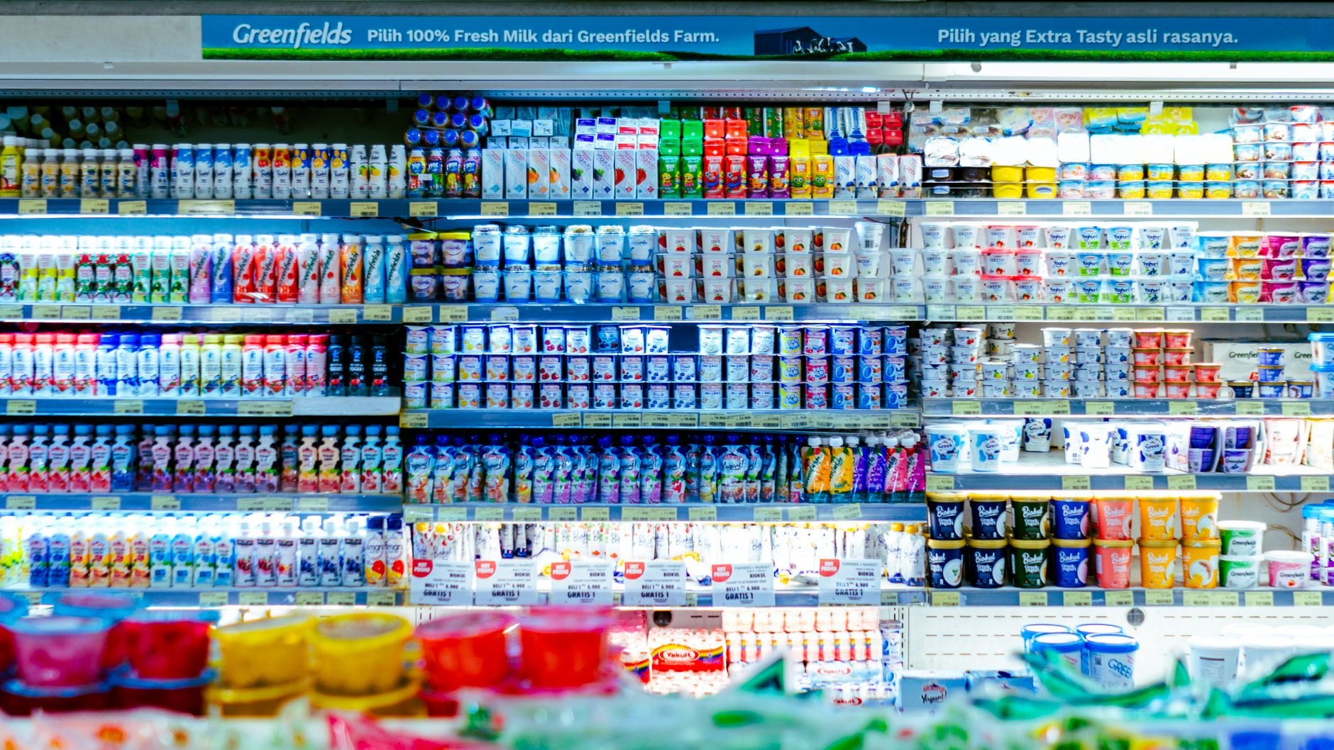 Fresh dairy products including milk bottles and cheese at refrigerated section