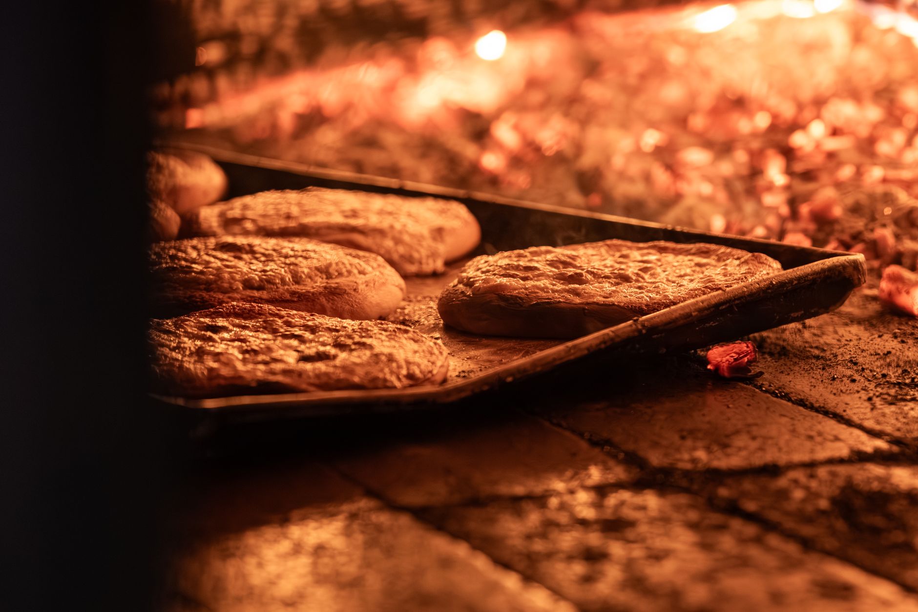Stone oven interior with glowing embers and traditional Turkish flatbread baking