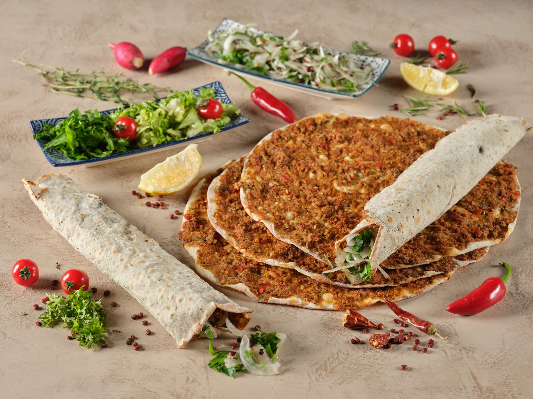 Overhead shot of Turkish pide with minced meat and fresh herbs from the oven