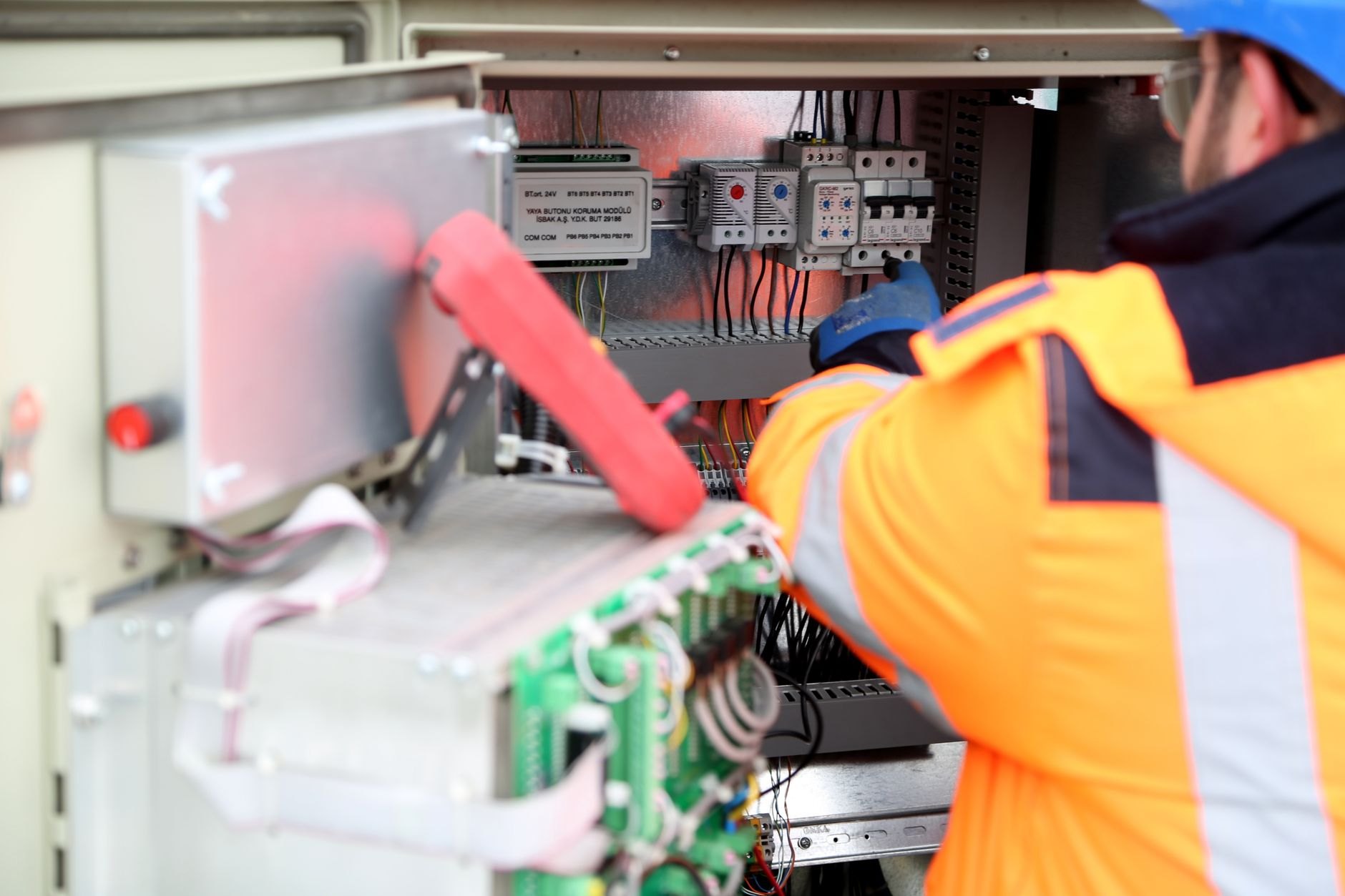 Electrician performing detailed wiring inspection on control panel